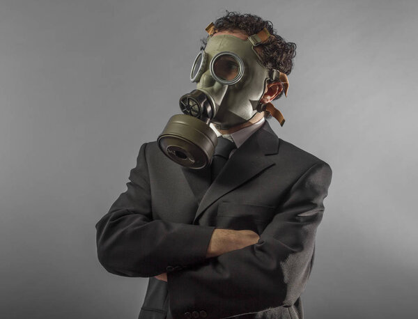 portrait of a business man with gas mask over grey background