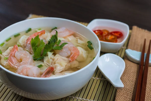 Karides Mantı çorbası ahşap masa üzerinde kızarmış domuz eti ile