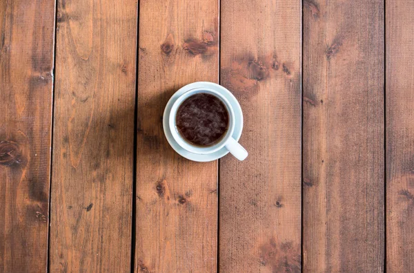Вид зверху чашка кави на дерев'яному фоні . — стокове фото
