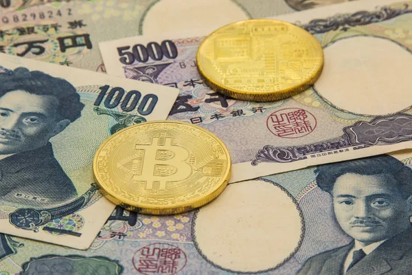 Une pièce symbolique de Bitcoin sur pile de nombreux billets de type japonais — Photo