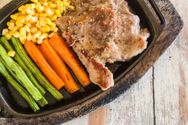 Sebze ile domuz eti biftek. Mısır, havuç, yeşil fasulye, ahşap