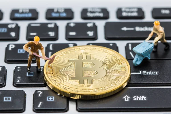Minyatür adam Tay klavye üzerinde madenciliği altın bitcoins kazma