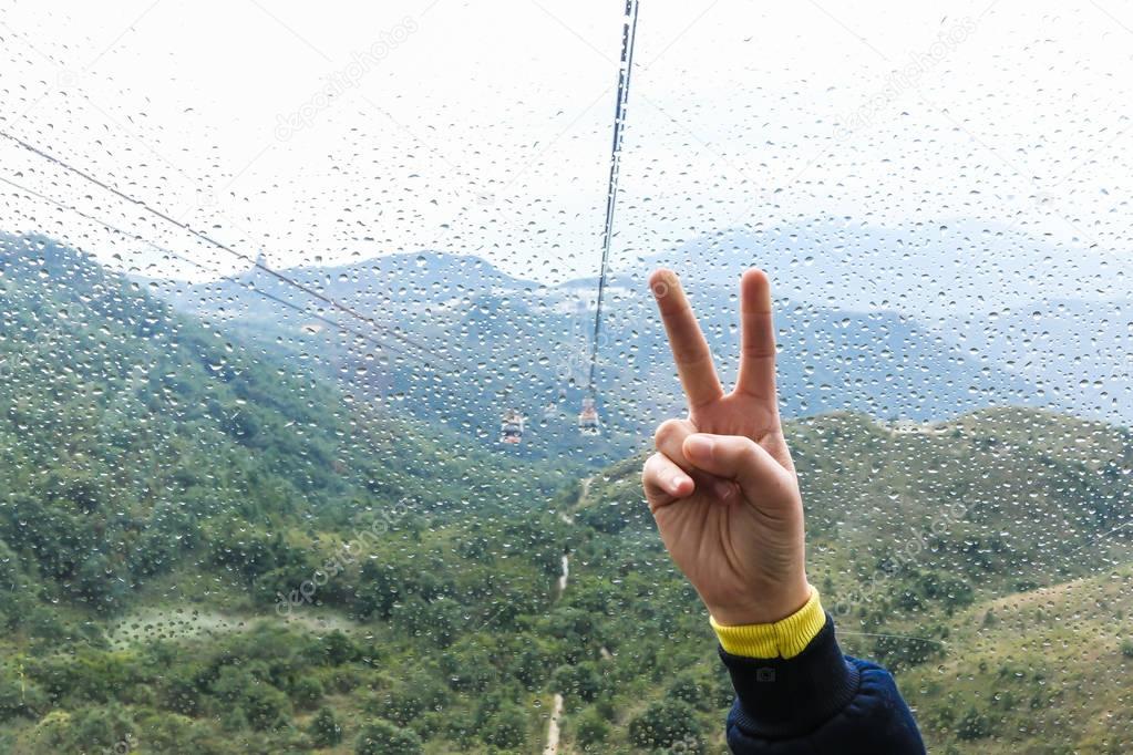 Woman showing Victory sign (v sign) in Cable Car Nong ping