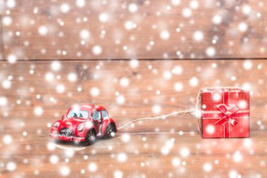 Kırmızı beetle araba kar yağışı üzerinde kırmızı hediye kutusu sürükleyerek