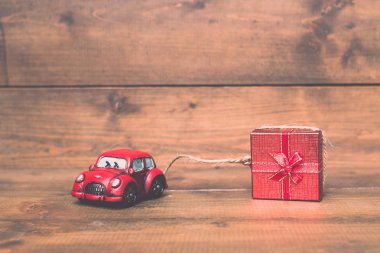 Kırmızı beetle araba sürükleyerek kırmızı hediye kutusu eski ve vintage rustik