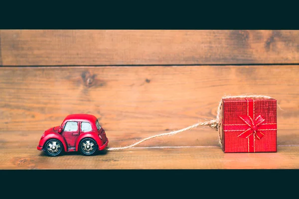 Red beetle car are dragging red gift box on old and vintage rustic