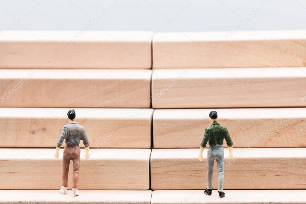 Miniature people : small figures businessmen walk up stair woode podium