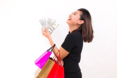 Güzel genç Asyalı kadın ile renkli alışveriş torbaları. Bir yandan para 100 dolarlık banknot beyaz arka plan üzerinde tutar..