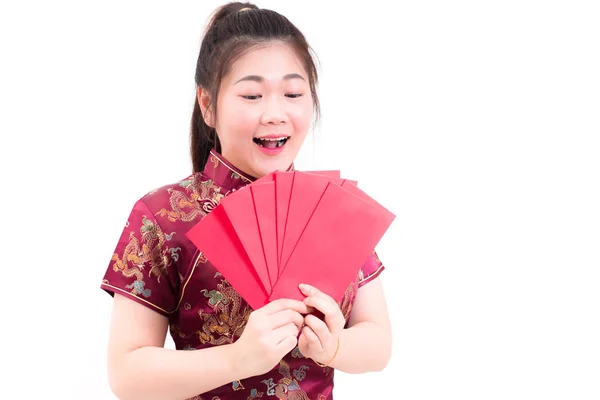 Красивая азиатка носит чонгсам на белом фоне. Держать красные конверты и улыбаться в китайском новом году . — стоковое фото