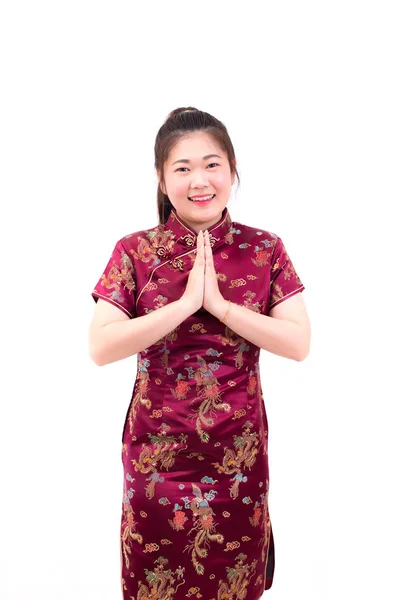 Mulher asiática vestindo cheongsam vestido chinês com gesto de parabéns, reunir as mãos em saudação ou obediência e sorrir em festividades de Ano Novo Chinês, Celebração de Ano Novo isolado . — Fotografia de Stock