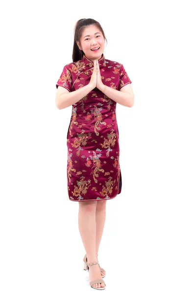 Azjatyckie dziewczyna ubrana w chińskich sukienka qipao gestem z gratulacjami, łączą ręce w pozdrowienie lub pokłon i uśmiech w chiński nowy rok uroczystości, obchody nowego roku na białym tle. — Zdjęcie stockowe