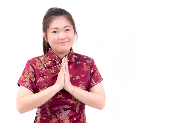 Mulher asiática vestindo cheongsam vestido chinês com gesto de parabéns, reunir as mãos em saudação ou obediência e sorrir em festividades de Ano Novo Chinês, Celebração de Ano Novo isolado . — Fotografia de Stock