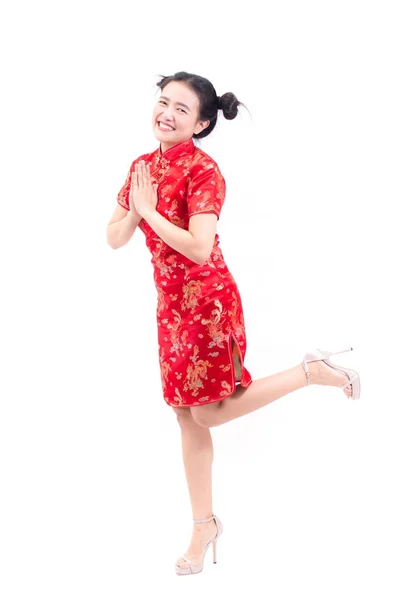 Asian woman wearing chinese dress cheongsam with gesture of congratulation, bring the hands together in greeting or obeisance and smile in Chinese New Year Festivities, New Year Celebration isolated. — Stock Photo, Image