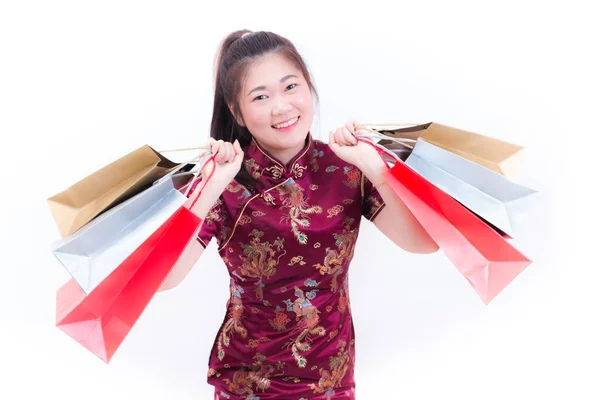 Молодая азиатка в китайском платье традиционного чонгсам с сумкой и улыбкой. Китайские новогодние праздники, празднование Нового года, концепция покупок, на белом фоне . — стоковое фото