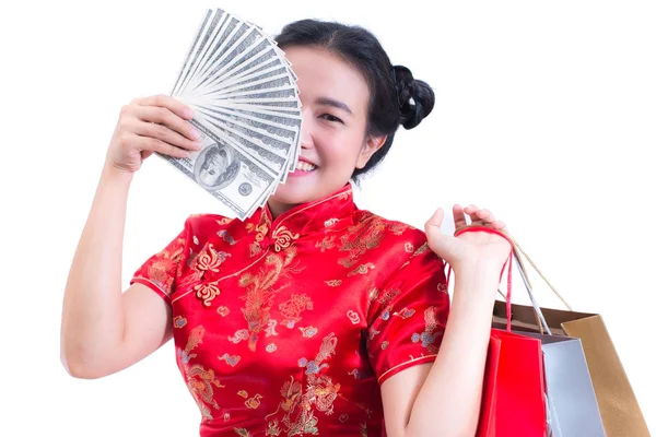 Krásná mladá asijská žena nosit čínské šaty tradiční cheongsam nebo QIPa s nákupní taškou a bankovky dolaru a úsměv. Čínský Nový rok oslavy, silvestrovské oslavy. — Stock fotografie