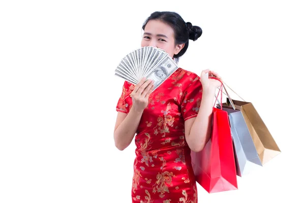 Belle jeune femme asiatique porter robe chinoise cheongsam traditionnel ou qipao avec Porter un sac à provisions et dollar billet et sourire. Fêtes du Nouvel An chinois, célébration du Nouvel An . — Photo