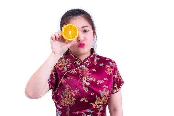 美丽的年轻亚洲女子穿着中国旗袍的传统礼服或旗袍。漂亮的女孩用橘汁抚摸她的脸用橙色的美人脸闭上眼睛。春节. — 图库照片