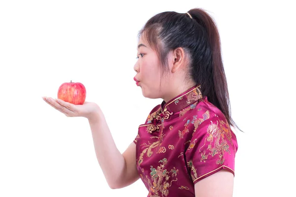 美丽的亚洲年轻女子的肖像穿中国传统旗袍或旗袍。吃红苹果, 孤立在白色背景, 健康, 中国新年庆典, 新年庆祝. — 图库照片