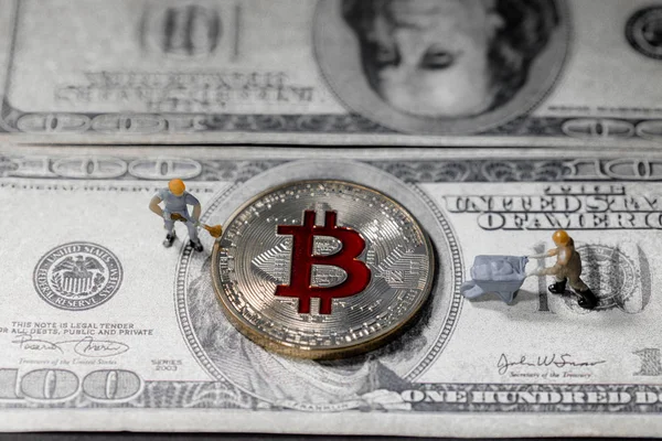 Górnickiego jest kopanie Golden bitcoin waluty cyfrowej na szczycie sto Dolar banknotów tła. Elektronika pieniadze, cyfrowy obraz koncepcyjny Bitcoin, wydobycie i handel. — Zdjęcie stockowe