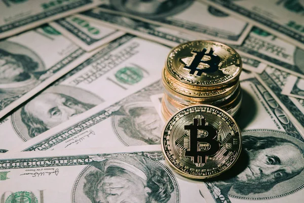 Купу укладання Золотий bitcoin на сто долар банкноти. одного монета перед камерою в зосередженою із заливкою на значок літера B на обличчі bitcoin, бізнес та торгівлі концепції. — стокове фото