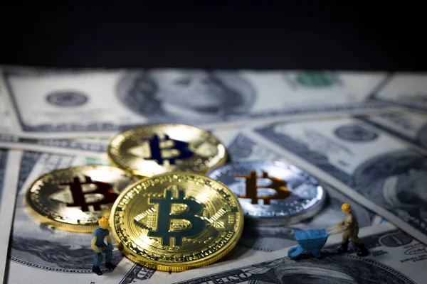 Górnickiego jest kopanie Golden bitcoin waluty cyfrowej na szczycie sto Dolar banknotów tła. Elektronika pieniadze, cyfrowy obraz koncepcyjny Bitcoin, wydobycie i handel. — Zdjęcie stockowe