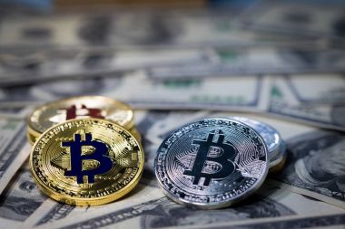 Yüz dolarlık banknotlar üzerinde yığın altın bitcoin yığını. Tek para bitcoin, iş yüzünde simgesi mektup B gölgelendirme ve kavram ticaret ile keskin odak kamera karşı karşıya.