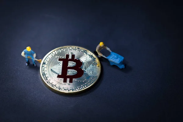 Маленький шахтёр ищет цифровую валюту Golden bitcoin на чёрном фоне. использование в качестве фонового бизнеса, концепция электронного обмена валюты, концептуальный образ добычи и торговли биткойнами . — стоковое фото