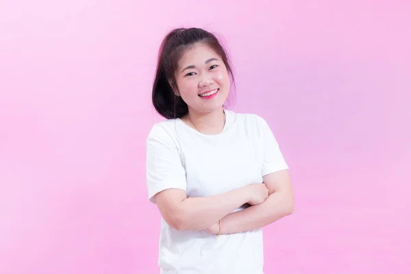 Retrato de bela jovem mulher asiática cabelo preto usar uma camiseta branca. Braços cruzados e sorrir olhando para a câmera . — Fotografia de Stock
