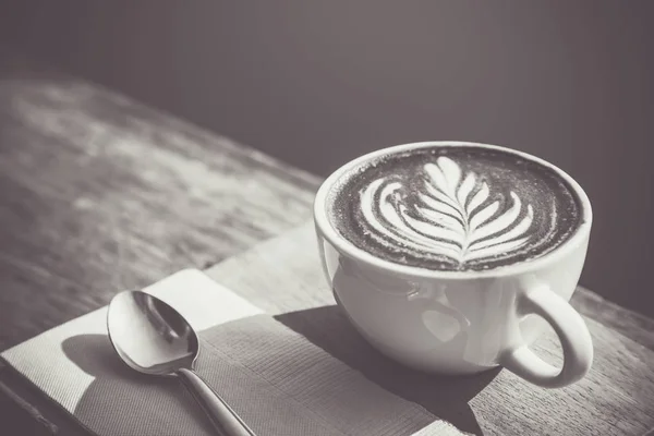 Positive thinking concept. Black and white of coffee cup art with spoon, Tissue, Chopping board on wooden table in coffee shop. Vintage style effect picture, with copy space