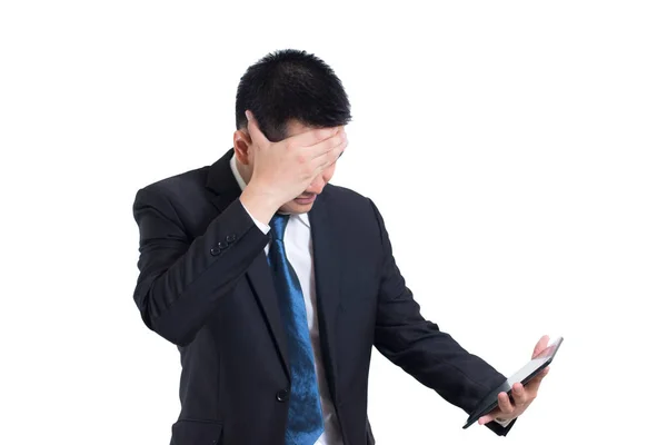 Moderno uomo d'affari asiatico mano tenendo tablet digitale che soffre di mal di testa su sfondo bianco. Nascondendosi faccia e confuso arrabbiato con infelice. faccia triste e in piedi e pensare negativo — Foto Stock
