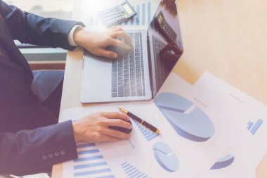İşle ilgili belgeleri ahşap masa üzerinde grafik mali diyagramın grafik kağıt üzerinde yazma ve dizüstü kullanarak modern iş adamı kapatın. İş başarısı, rapor, büyüme, pazarlama planı, yatırım.