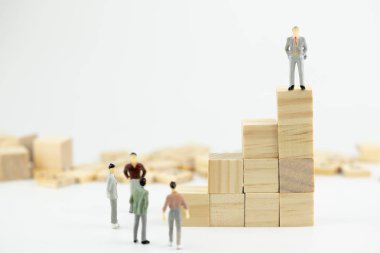 İş lideri kavramı. Minyatür ahşap blok istifleme içinde küçük bir rakam duran insanlar. Kopya alanı ile. Takım çalışması, yönetim, iş adamı, liderlik