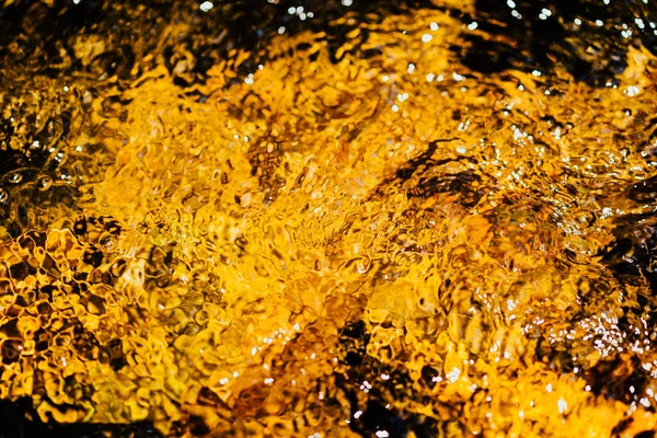 Autumnal golden yellow blurry abstract water background. Formed from sunny reflections of forest trees and movement in a river. With copy space for your text, Wallpaper, Backdrop, Water fall, Nature.