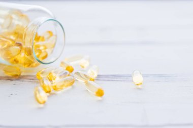 Omega 3 hapları ve arka planı bulanık olan bir sürü kapsül. Şişedeki D-3 vitamini kapsülleri. Beslenme takviyeleri, ilaçlar, eczane, tıp ve sağlık hizmetleri konsepti.