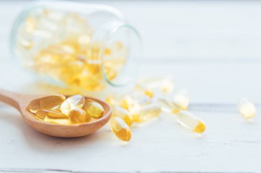 Omega 3 hapları ve arka planı bulanık olan bir sürü kapsül. Şişedeki D-3 vitamini kapsülleri. Beslenme takviyeleri, ilaçlar, eczane, tıp ve sağlık hizmetleri konsepti.