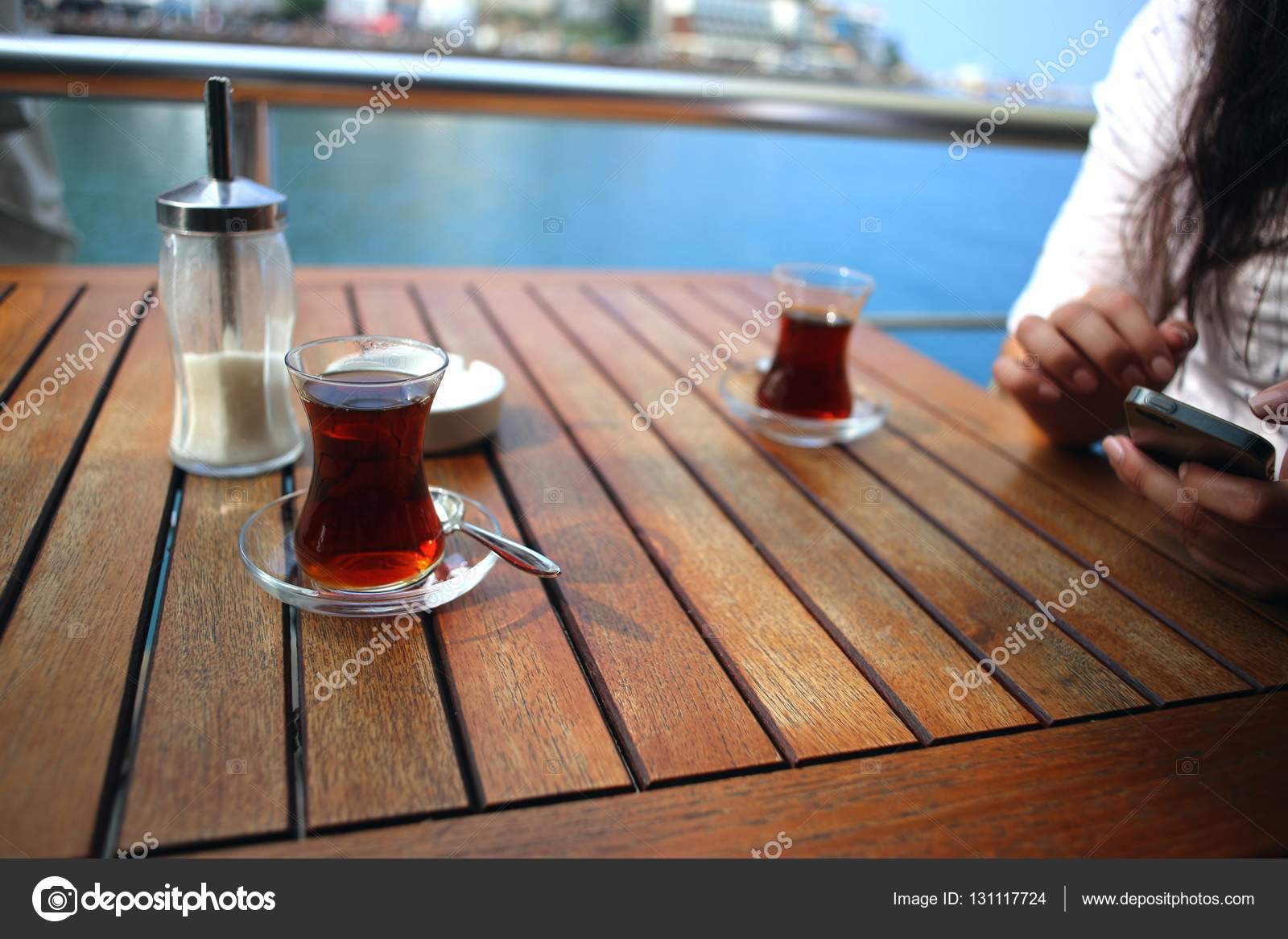 Mujer joven que utiliza un teléfono móvil en el parque con