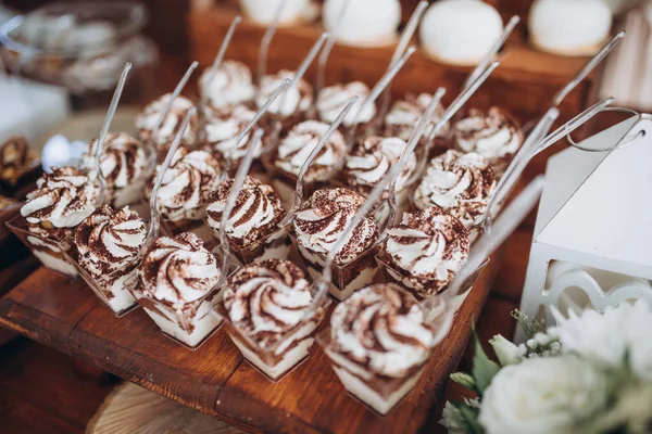 Table à dessert sucrée ou barre chocolatée. Fête de mariage. Lumière naturelle. Macaron et pyramide de meringue. Gâteaux et guimauve . — Photo