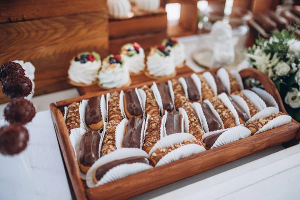 Table à dessert sucrée ou barre chocolatée. Fête de mariage. Lumière naturelle. Macaron et pyramide de meringue. Gâteaux et guimauve . — Photo