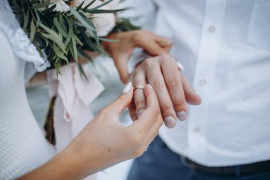 Gelinlik giymiş güzel bir kız damadın parmağına takar alyansı