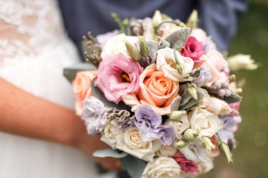 Kırmızı, pembe ve beyaz çiçekli güzel düğün buketi, güller ve okaliptüsler, şakayıklar, zambaklar