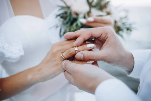 a man wearing a wedding ring on his wife\'s finger