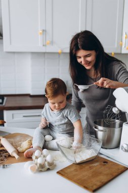 Mutfakta mutlu bir aile. Anne ve oğul hamuru hazırlıyorlar, kurabiye pişiriyorlar.