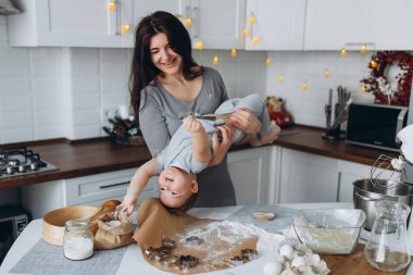 Mutfakta mutlu aile zamanları. Anne ve oğlu oyun oynuyorlar..