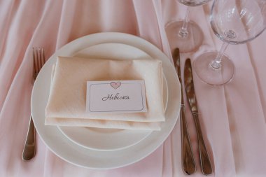 Bıçak, beyaz tabak ve bej arka planda çatal..