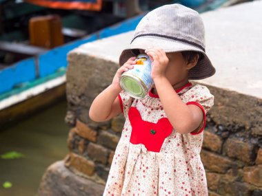 Small girl drinking sweetened, condensed milk clipart