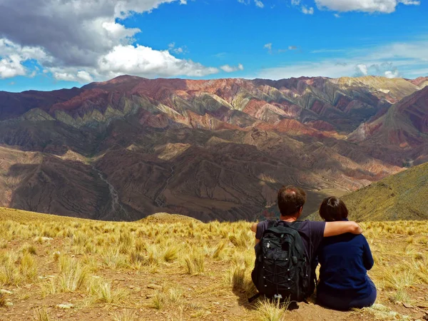 Пара сидить на траві і дивиться на гори з іншого боку долини . — стокове фото
