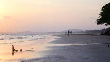 İnsanlar akşamları sahilde yürüyorlar..