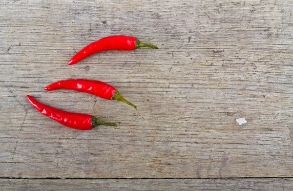 Rote Chilischoten auf Holztisch — Stockfoto