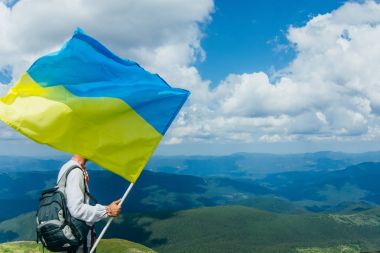 Ukraynalı adam yürümek Hoverla dağ ulusal bayrak ile tepesinde