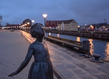 Klaipeda, Litvanya - 1 Mayıs 2015: Dane nehir kıyısında Kiss heykel. Kız bir heykel bir çocuğun nehrin diğer tarafında bir öpücük göndermek. Romualdas Kvintas tarafından işe.